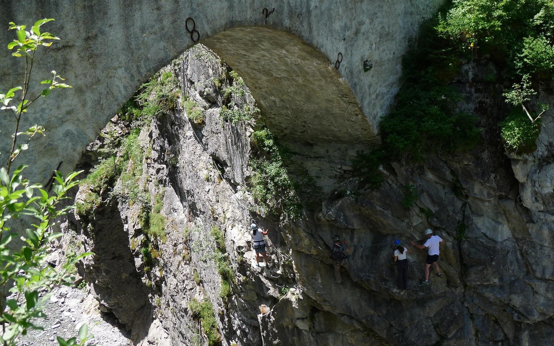 Gorges de Mauvoisin via ferrata, section one: Saxifrage, passing beneath the old arched bridge.