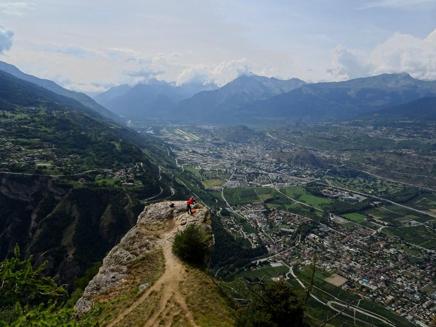 The exposed viewpoint at the finish. Below: the urban sprawl of the city of Sion on the valley floor.